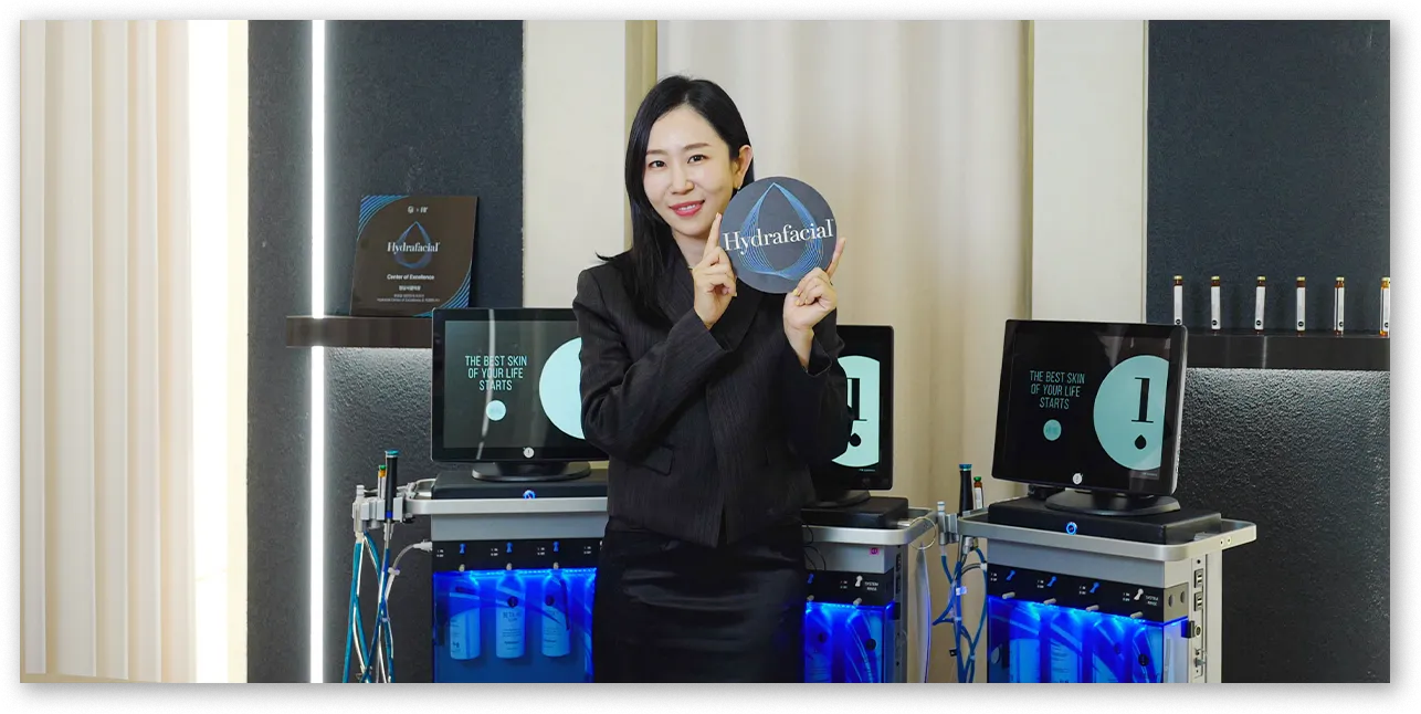 하이드라페이셜 장비 앞에서 엠블럼을 든 대표원장