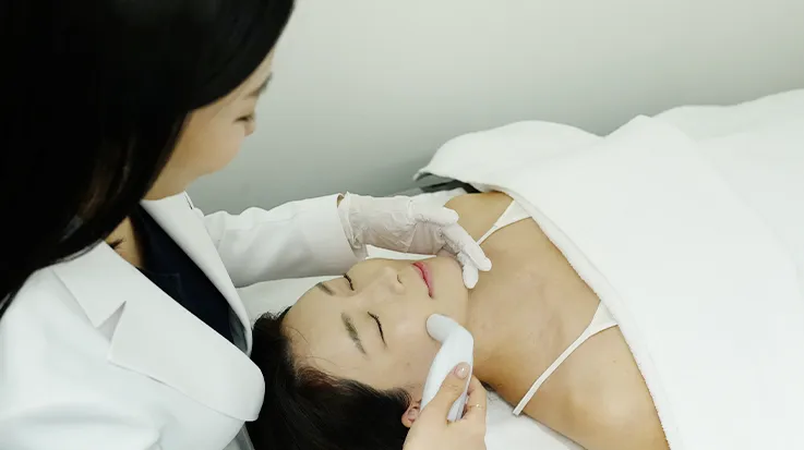 누워 있는 환자의 목 부위를 관리하는 의료진
