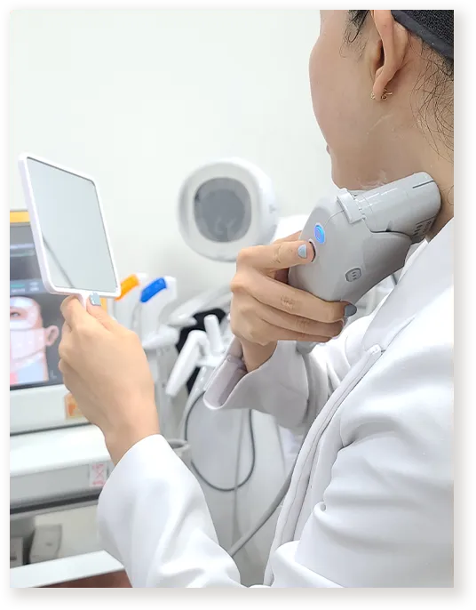 환자가 거울을 보는 동안 목 부위를 시술하는 모습